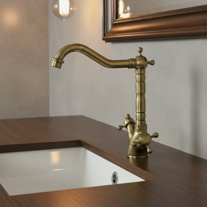 Brass kitchen faucet with a basket of apples and bananas on a white countertop.