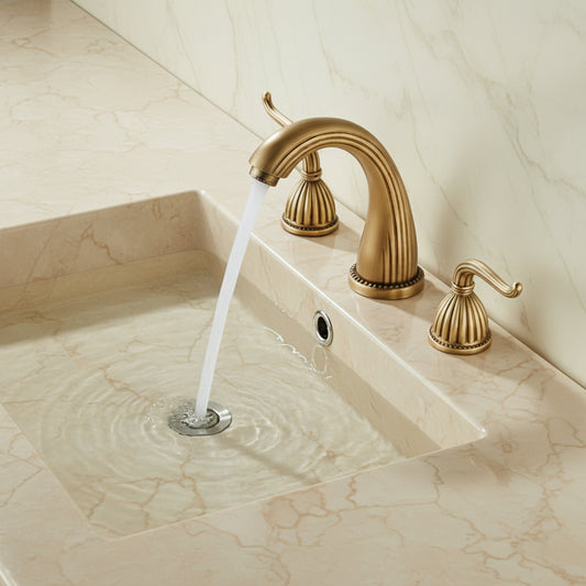 Gold faucet with water flowing into a sink in a bathroom setting.