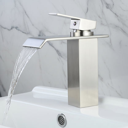 Silver faucet with water flowing into a sink against a brick wall background