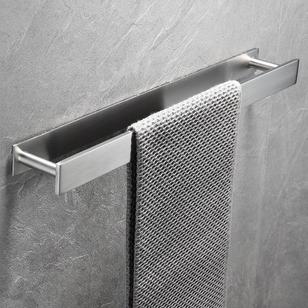 Brushed metal towel rack with a towel on a gray tiled wall